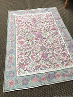 Full view of rug laid flat showing entire floral pattern and border