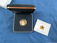 Coin and certificate displayed in open black presentation case