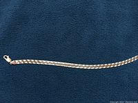 Full length view of herringbone bracelet showing clasp and chain details