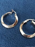 Pair of hoop earrings on blue background showing front view of both earrings