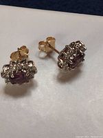 Pair of earrings on white surface showing full design and contrast of metals