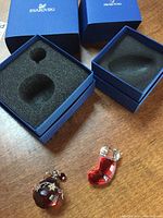 Both Swarovski crystal Christmas ornaments shown in their detail and original blue branded boxes