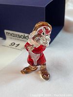 Front angle of crystal Grumpy figurine showing red coat and clear beard