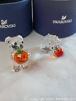 Photo showing Swarovski Kris Bear and hedgehog with apple crystal figurines with branded blue boxes in the background.