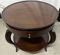 Top view of the round wooden table showing the smooth table surface and curved legs.