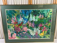 Framed watercolor print showing dense colorful flowers in an expressive style with a green double mat and thin gold and white frame.