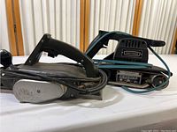 Elu power planer and Craftsman belt sander shown side by side on a white surface.