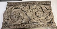 Full view of rectangular wall hanging showing carved floral swirls and ornamental border