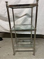 Full view of the metal and tempered glass shelf, showing frame and three glass shelves.