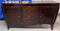 Front view of the Brownstone dark wood dresser showing drawers, cabinet doors, and metal knobs.
