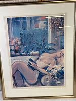 Full view of the framed print showing the nude woman reading and the floral background.