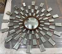 Full view of vintage starburst mirror artwork showing central convex mirror and surrounding beveled mirror rays on bronze metal rods.