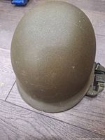Top view of the vintage army helmet showing its olive drab outer shell with light wear.