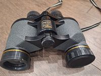 Top view of vintage Magnascope Rapid Focus binoculars showing brand label and central focusing knob.