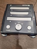 Front view of the Retron console showing three cartridge slots and power/reset buttons.