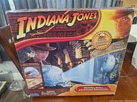 Front of the box showing Indiana Jones branding, image projector light beam highlighting skull, detail of the projector toy and branding text.