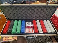 Full poker set including poker chips, two decks of playing cards, and dice organized in an aluminum storage case with foam lining.