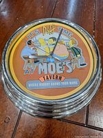 Front of clock showing Moe's Tavern scene with Simpsons characters and caption 'It's Duff Time at Moe's Tavern - Where Nobody Knows Your Name'