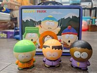South Park lunch box with front graphic of characters Cartman, Kyle, Kenny, and Stan with three figures.