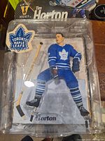 Photo of Tim Horton figure in blue Toronto Maple Leafs jersey, visible in blister packaging with a black and blue card backing labeled 'Vintage Hockey Tim Horton'