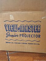 Close-up of the original packaging box with 'VIEW-MASTER Junior PROJECTOR' branding from Sawyer's Inc., Portland, Oregon, USA.