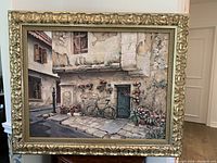Full view of the framed painting showing the European street scene with bicycle and flowers.