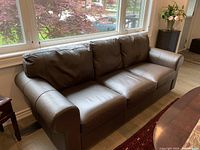 Front view of brown leather couch showing overall design and condition