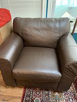 Front view of brown leather armchair on patterned rug