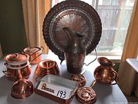 Photo showing full assortment of copper items including large tray, pitchers, cookware and molds.