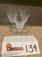 Five Waterford Lismore crystal wine glasses displayed on a countertop, showing their full height and shape.
