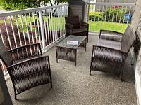 Group view of the entire four-piece patio set arranged on a porch