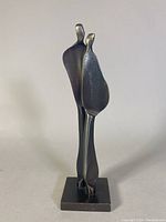 Front view of abstract steel sculpture showing two joined figures on square base