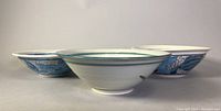 Front side view showing the profile of the three pottery serving bowls with artistic blue and green designs.