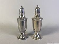 Front view of the pair of sterling silver salt and pepper shakers showing their shape and surface condition.