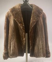 Front view of brown vintage mink fur jacket on a mannequin showing the plush fur texture and wide collar.