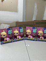 Four Baby Alive dolls in original packaging displayed on table.