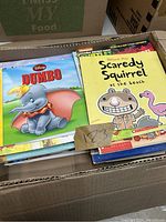 Box of assorted children's books showing Dumbo and Scaredy Squirrel titles on top.