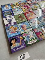 Photo showing 20 Disney-themed children's square board books arranged in rows, featuring characters like Cinderella, Tiana, Elsa, Minnie Mouse, and My Little Pony.