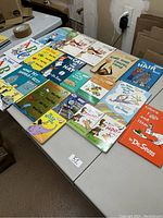 Overview of the lot of 18 Dr. Seuss books laid out on table, showing various popular titles, colorful covers, and very good condition.