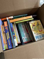 Top view of the box showing colorful children's books stacked, including Monster Machine, Do You Get It? and more.