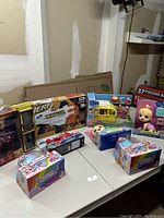 Display of lot including NERF Ultra AMP blaster, Baby Alive doll, Hatchimals boxes, and other toys