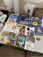 Overview of children's books including Star Wars, superheroes, manga, and science-themed books laid out on table.
