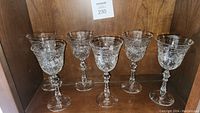 Set of six Rock Sharpe crystal goblets displayed on wooden surface, showing the shape and cut pattern on all goblets.