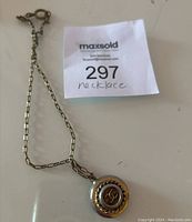 Photo of the full necklace chain and circular pendant with double C logo showing front view.