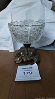 Vintage cut glass bowl on an ornate brass pedestal base, showing overall detail and condition of the lot.