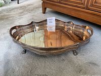 Angled view of the tray showing the footed base, two handles, and perforated gallery sides with visible tarnish.