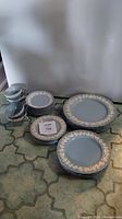 Full set of blue and white Wedgwood dishes including plates, bowls, cups, and saucers arranged on floor.
