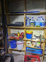 Shelf with cleaning supplies, gardening trays, buckets, plumbing parts, hand tools, and boxed light bulbs