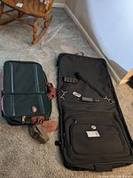 Samsonite carry-on bag next to American Tourister garment bag on carpet, viewed from front and top side