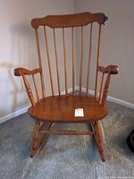 Front view of the wooden rocking chair showing overall structure and finish.
